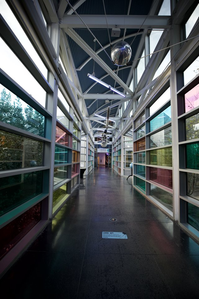 Modern Glass Corridor with Colorful Reflections at Science Center