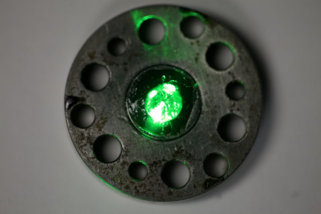 Glowing Emerald Gemstone on Metal Plate
