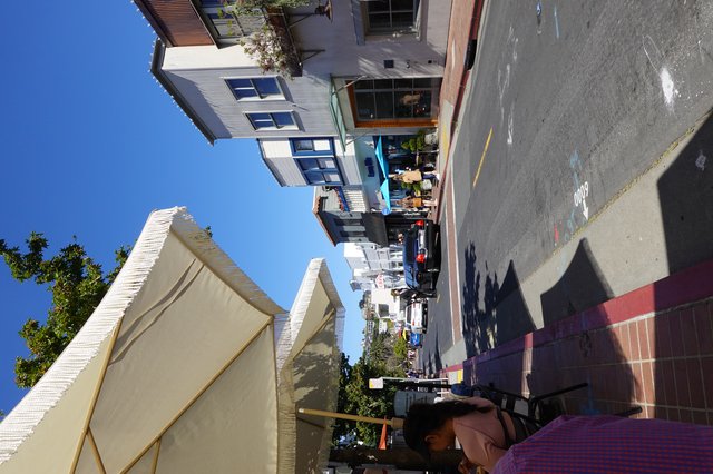 Sunny Coastal Town Street Scene with Umbrella