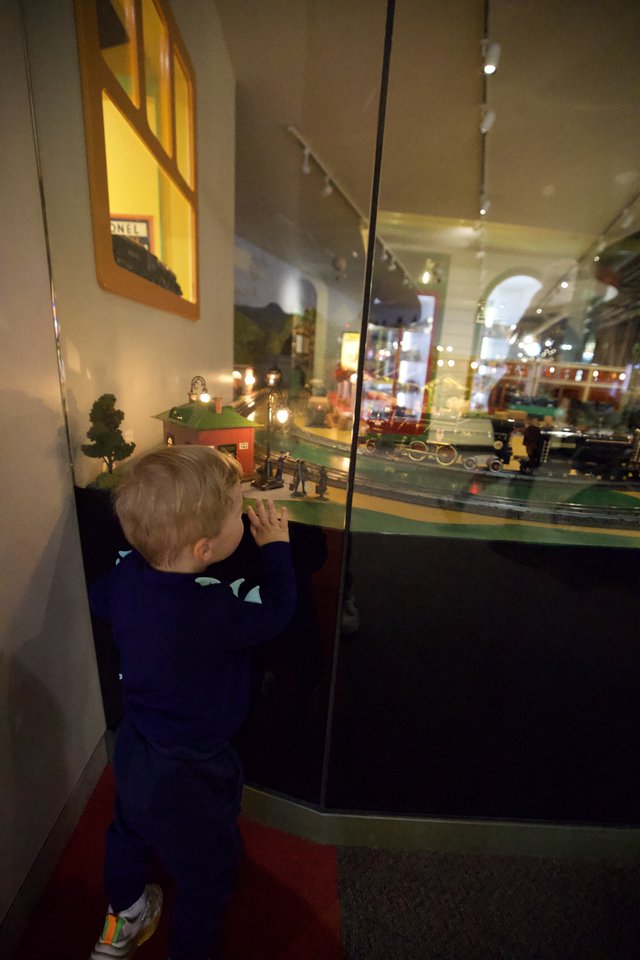 Young Child Mesmerized by Vintage Train Display