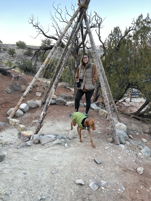 Woman and Dog Admiring Teepee in the Wilderness