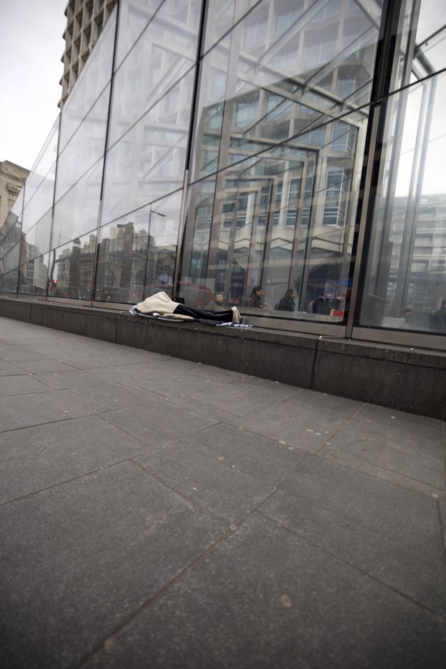 Homeless Person Sleeping Outside Modern Glass Building