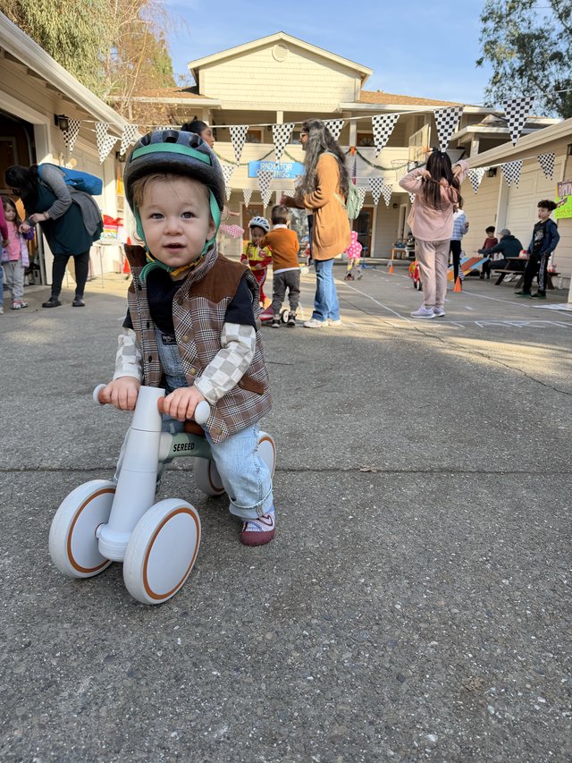 Young Child on Balance Bike at Neighborhood Block Party