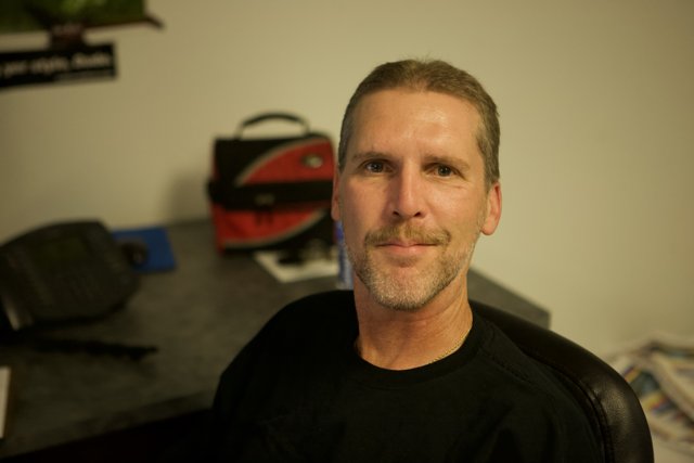 Smiling man with a black shirt and mustache
