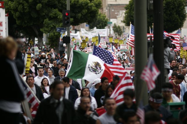 Unity in Diversity Caption: A large crowd of people carrying Mexican and American flags came together for a student protest in 2006, showcasing the power of unity amidst diversity. Madhuri Mehta captures the vibrant energy of the moment through this photograph.