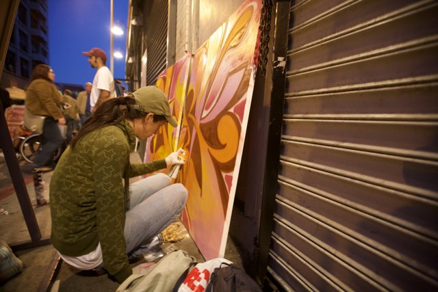 Urban Artistry: A Woman Painting a Mural on the Side of a Building