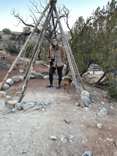 Woman and Dog next to Teepee in the Wilderness