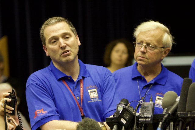 Press Conference with Two Men in Blue Shirts