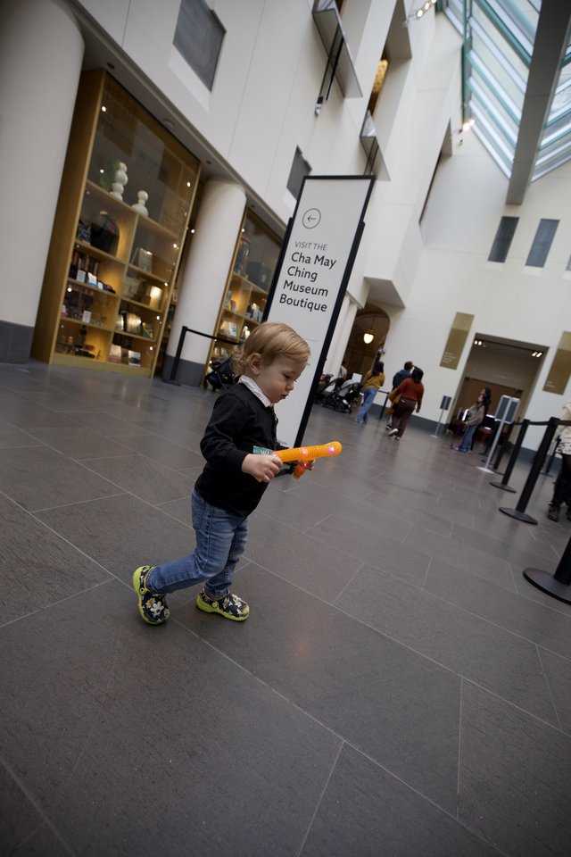 Young Child Exploring Asian Art Museum with Toy