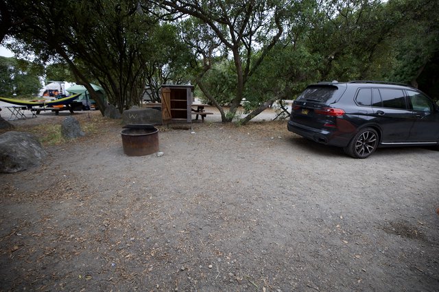 BMW SUV Parked at Shaded Campground Fire Pit