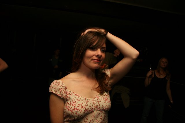 Young Woman Dancing at Dimly Lit Venue
