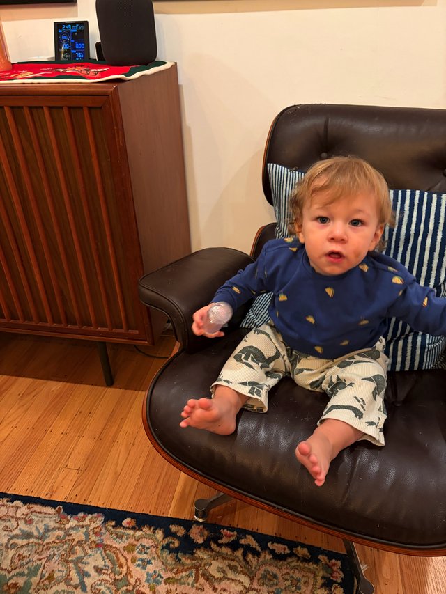 Toddler Relaxing in Vintage Leather Chair at Home