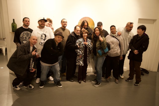 Group of 14 friends pose for a photo in art gallery