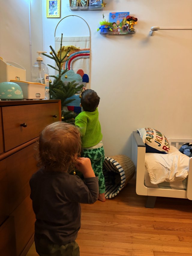Children Decorating Small Christmas Tree in Bedroom