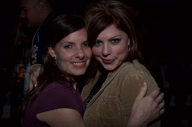 Two Friends Embrace at a Nighttime Event