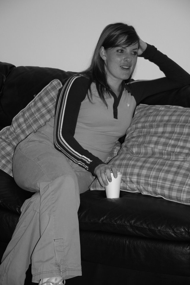 Young Woman Relaxing on Leather Sofa with Drink
