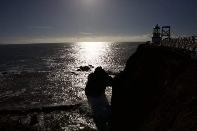 Silhouette of a Lighthouse on a Promontory