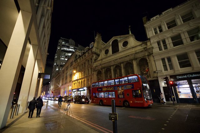 Red Double-Decker Bus on London Street at Night