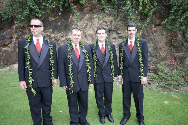 Four Men in Suits Posed by a Rock Wall