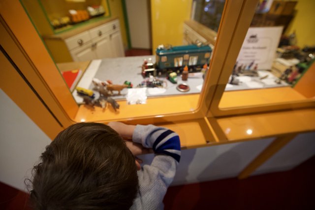 Child Exploring Museum Display Through Glass Case