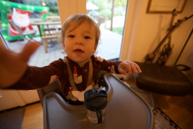 Toddler in Festive Pajamas Reaching Toward Camera