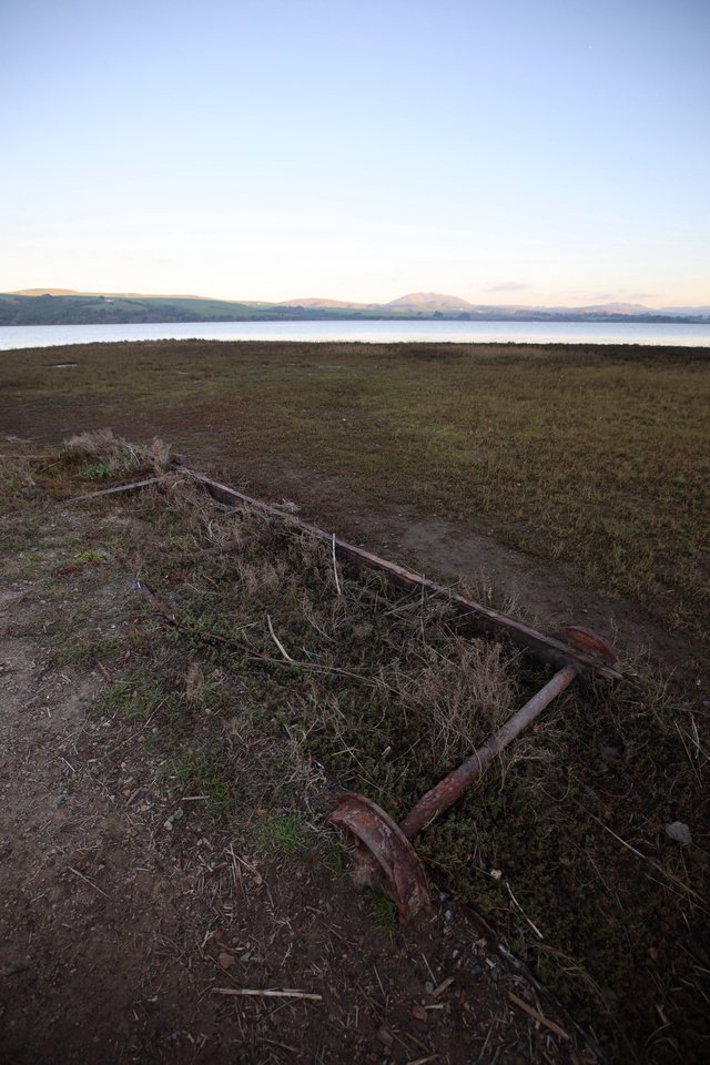 Rusted Anchor Resting on Coastal Grassland at Dusk