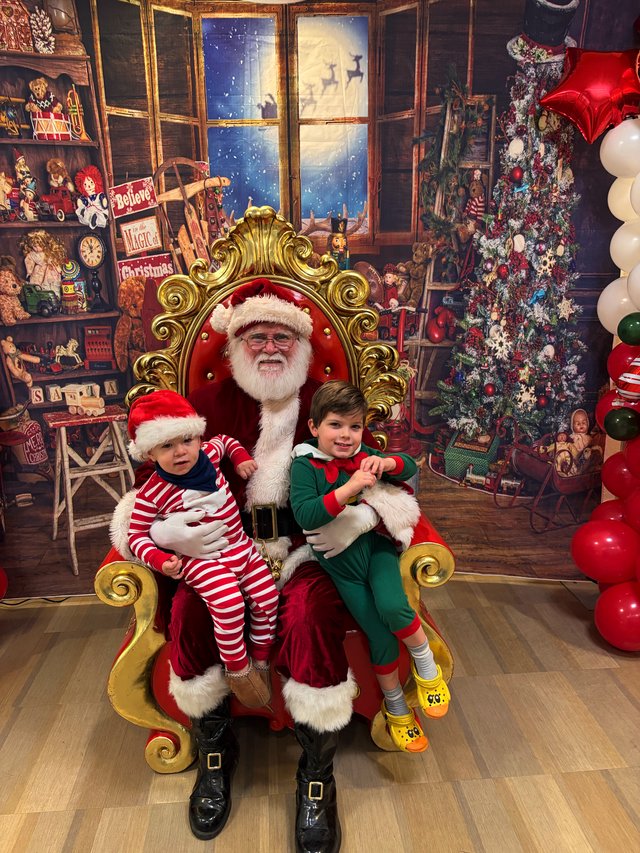 Two Children Visit Santa in His Workshop Grotto