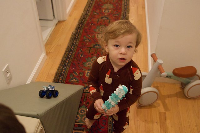 Toddler in Santa Pajamas Holding Christmas Toy