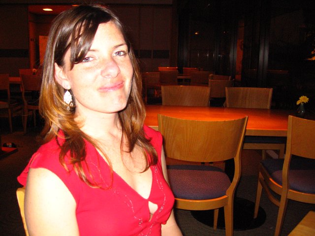 Woman in Red at Dimly Lit Restaurant Table