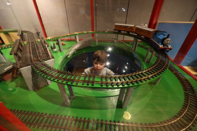 Child Observing Model Train Display in Museum Dome