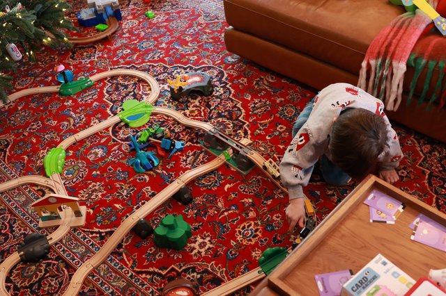 Child Playing with Wooden Train Set on Christmas Day