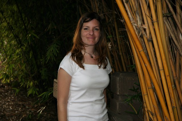 Woman Smiling Among Bamboo in Garden Setting