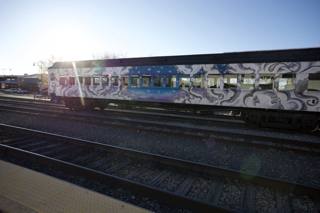 Graffiti-Covered Train Car at Sunset on Railway Tracks