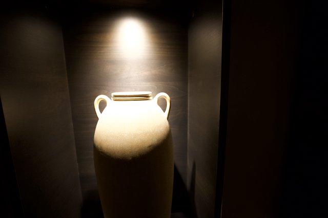 Illuminated White Amphora in Museum Display Niche