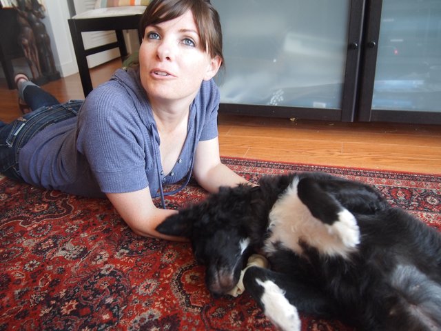 Woman Relaxing on Rug with Black and White Dog