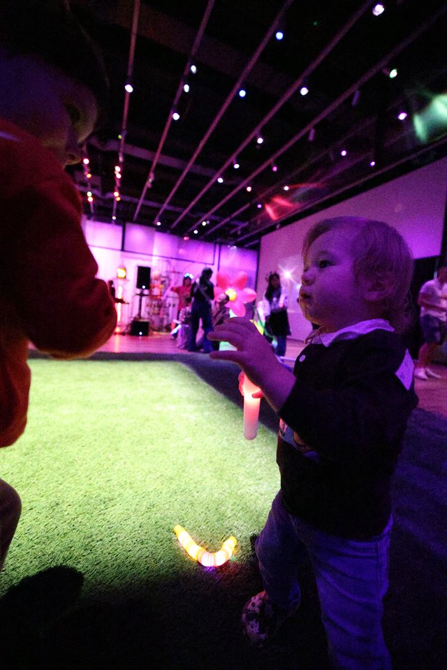 Child Dancing with Glow Stick at Baby Rave Event