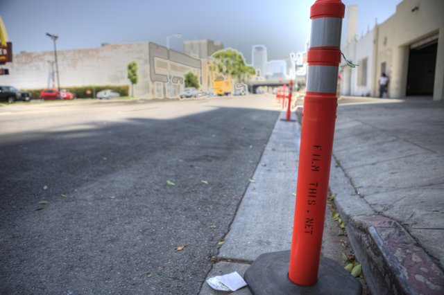 Red and White Traffic Cone in Urban Landscape