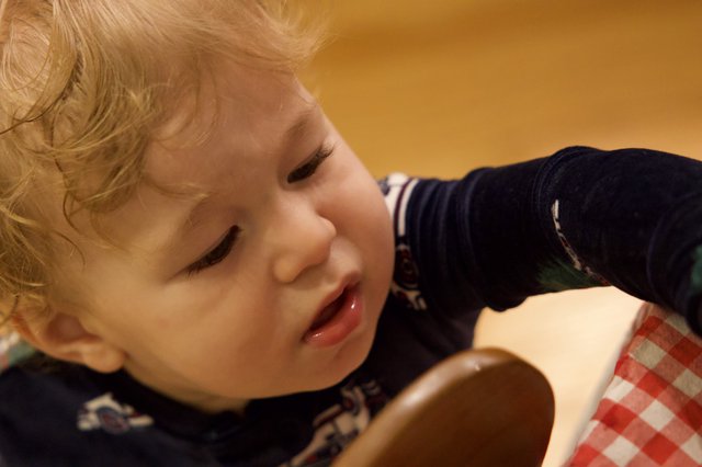 Curious Toddler with Blonde Hair at Mealtime