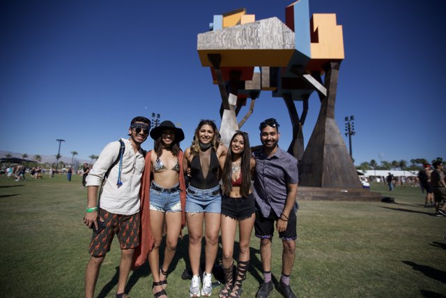 Four Friends Strike a Pose in Front of a Sculpture
