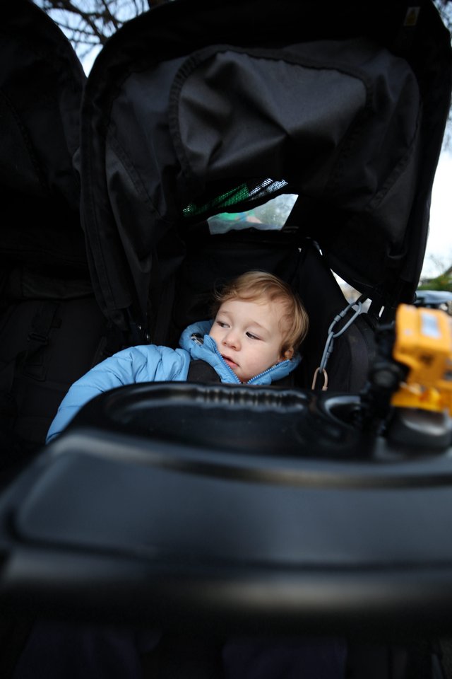 Curious Toddler Explores Stroller Storage Compartment