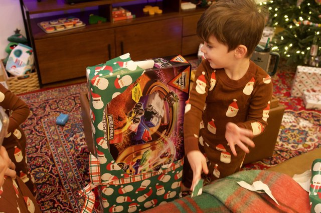 Young Boy Unwrapping Large Christmas Gift