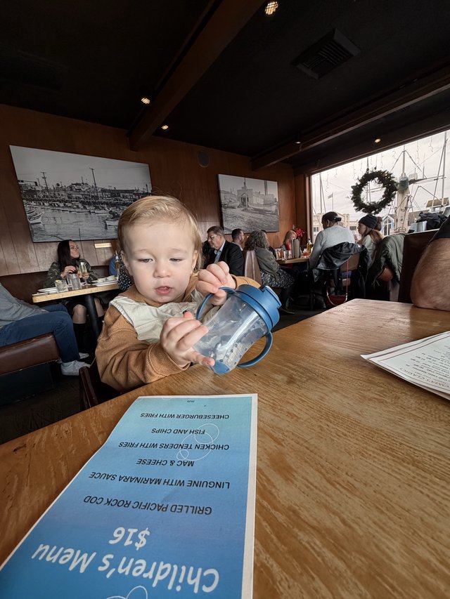Young Child with Sippy Cup at Restaurant Table