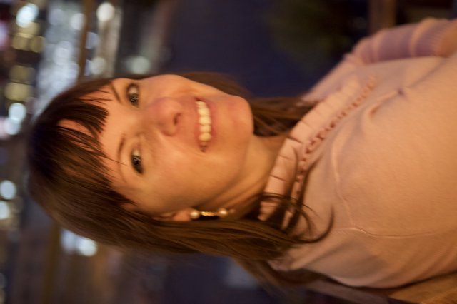 Smiling Woman at Night with City Lights Behind