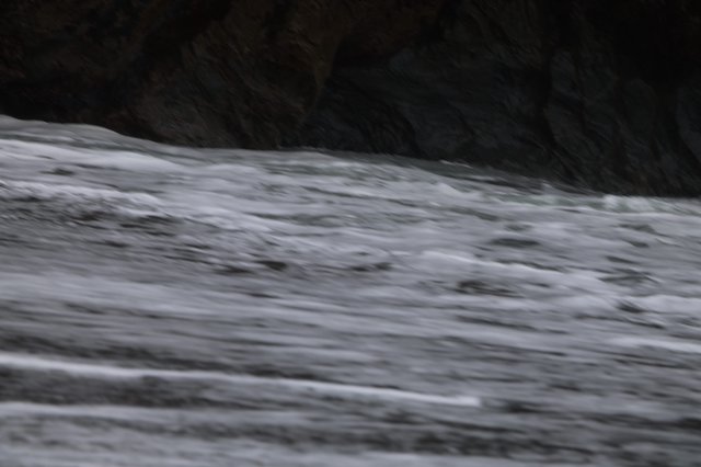 Churning Ocean Waves Against Dark Rocky Cliffs