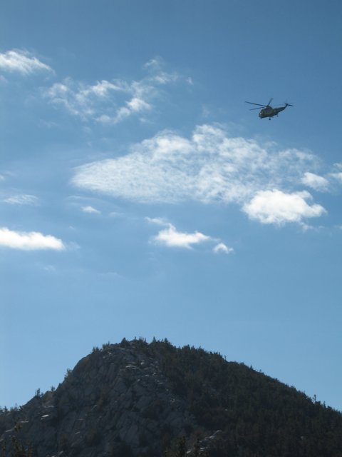Helicopter Soaring Above Majestic Mountain Landscape