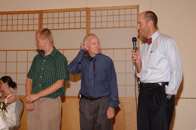 Three Men Share a Moment at Wedding Reception