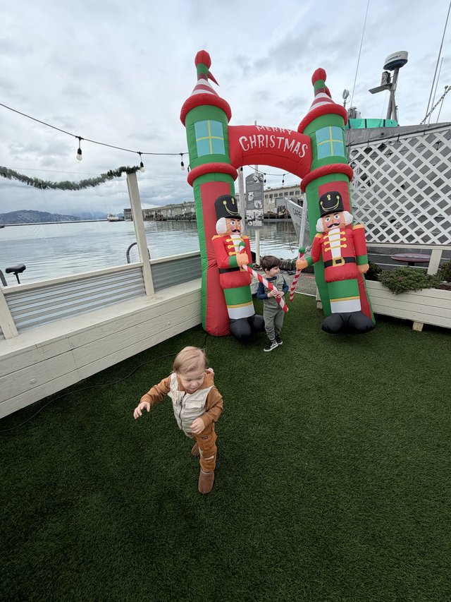 Children Playing Near Inflatable Christmas Decorations by the Water