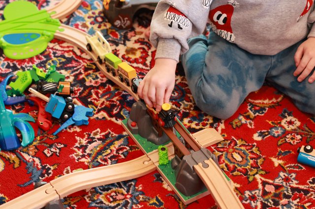 Child Playing with Wooden Train Set on Christmas Day