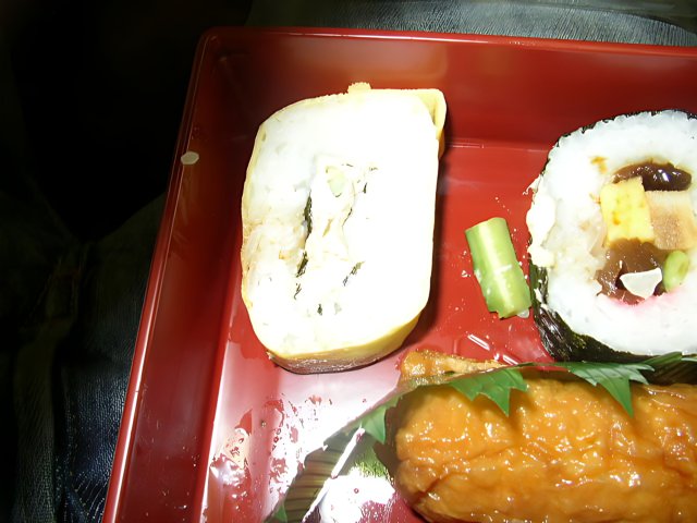 Appetizing Sushi Roll and Fresh Vegetables on a Red Tray