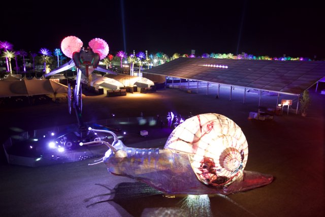 Illuminated Snail Sculpture Shines Bright in Night Sky